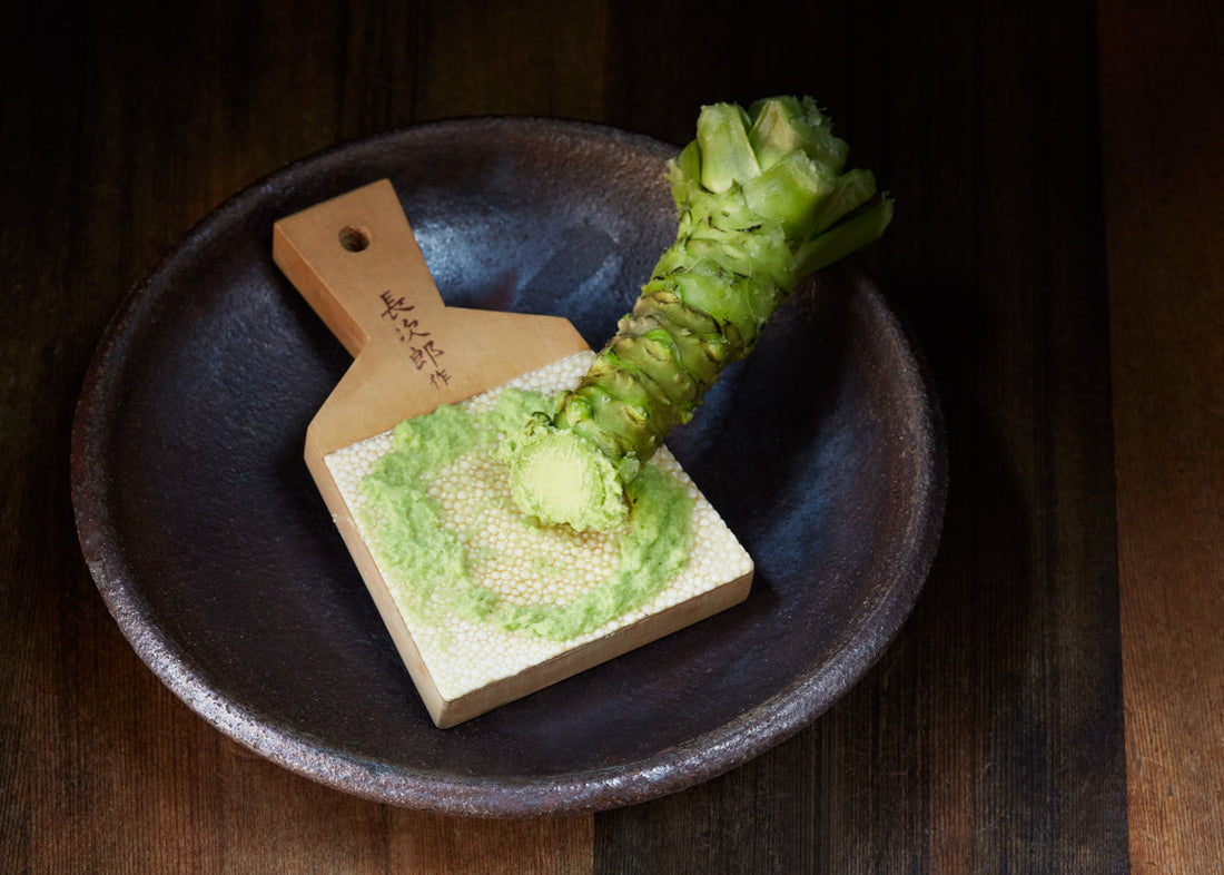 Wasabi rhizome and grated, fresh wasabi resting on a sharkskin grater