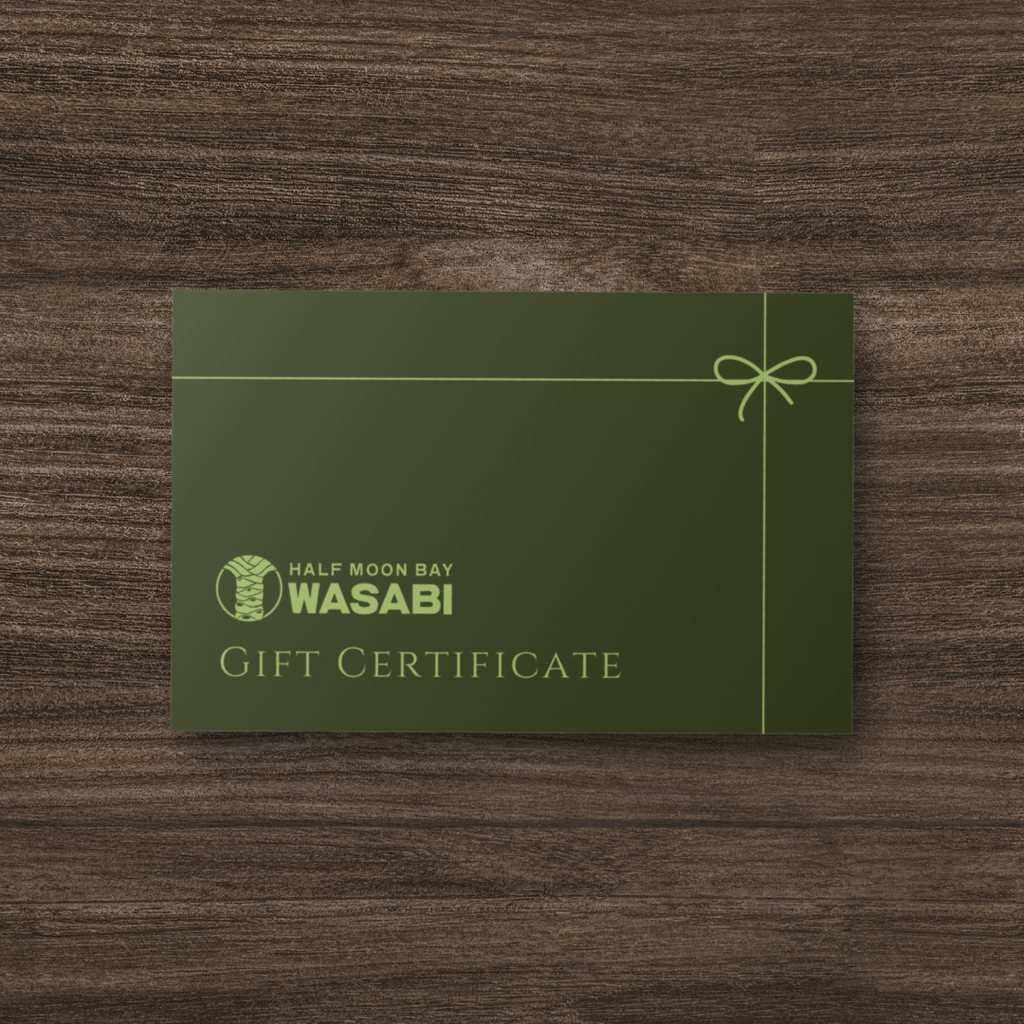 Green gift certificate for Half Moon Bay Wasabi on a wooden surface
