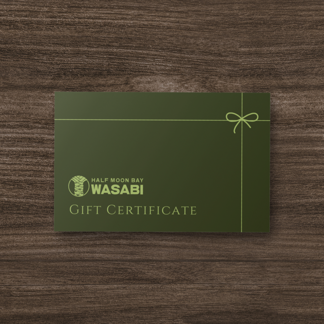 Green gift certificate for Half Moon Bay Wasabi on a wooden surface